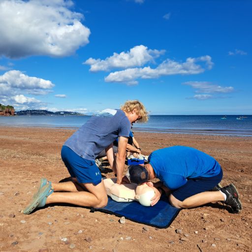 Participants practising first aid on the beach