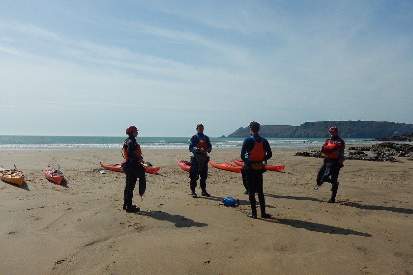 sea kayak group talking on beach